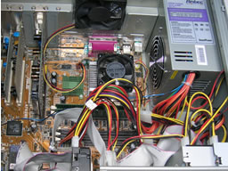 Power unit intake fan aligns with CPU exhaust. Case fan operates perpendicularly to them. A tight tangle of ribbon cables flow between the power lines.