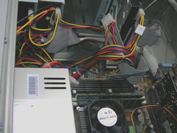 Close view of a power line jumping from DVD to CD to floppy drive. Hard drive uses a separate line.