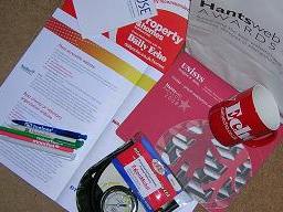 Goody bag from the award, featuring: event programme, branded pens, cup, notepad, mousepads and tyre pressure guage.